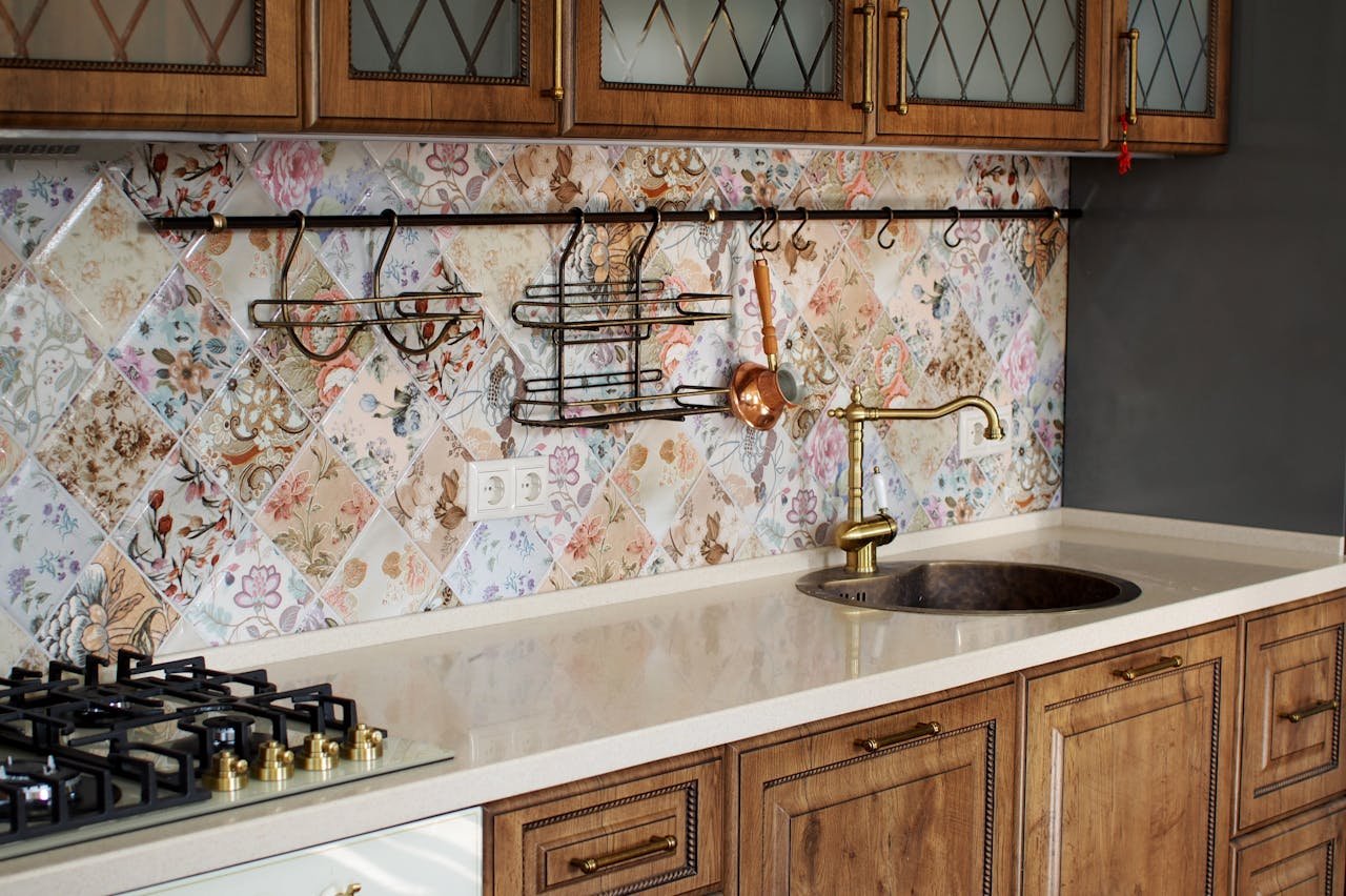 Elegant kitchen interior featuring wooden cabinets and a floral tile backsplash.